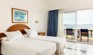 Hotellrom med to enkeltsenger og balkong med havutsikt. (AI-generert tekst)