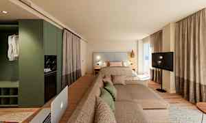 Moderne hotellrom med seng, sofa og TV foran store vinduer. (AI-generert tekst)