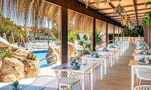 En terrasse restaurant med dekkede bord ved et basseng. (AI-generert tekst)