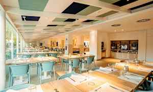 Innendørs omgivelser av en restaurant med dekkede bord og lys innredning. (AI-generert tekst)