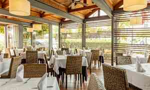 Restaurant med dekkede bord og store vinduer. (AI-generert tekst)