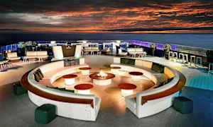 En takterrasse med sitteplasser, sofagrupper og et sentralt oppsett med ild. (AI-generert tekst)