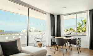 Et lyst rom med store vinduer som viser utsikt mot havet og natur. (AI-generert tekst)