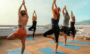 En gruppe mennesker utfører yogaøvelser på en terrasse. (AI-generert tekst)