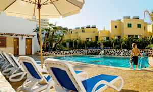 Bilde av et utendørs svømmebasseng omgitt av solsenger og vegetasjon. (AI-generert tekst)