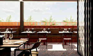 En utendørsrestaurant med bord og stoler, med en trevegg og utsikt mot palmer under en klar himmel. (AI-generert tekst)