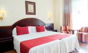 Dobbeltrom med rød innredning og to lenestoler. (AI-generert tekst)