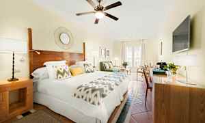 Et lyst hotellrom med dobbeltseng, tredetaljer og moderne innredning. (AI-generert tekst)