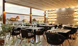 Solbelyst restaurantmiljø med elegant oppsatte bord og stoler. (AI-generert tekst)