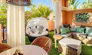 En møblert balkong med solsenger, bord og plantepynt. (AI-generert tekst)