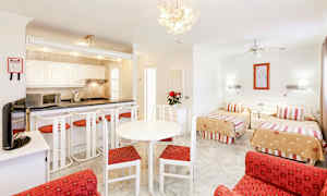 Rom med to enkeltsenger, sittegruppe og kjøkkenkrok. (AI-generert tekst)