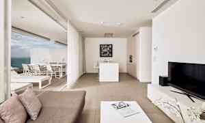 En moderne leilighet med åpen planløsning, lys innredning og utsikt mot havet. (AI-generert tekst)