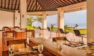 Uteservering med havutsikt og tremøbler. (AI-generert tekst)