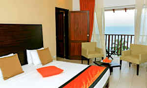 Bilde av et hotellrom med en seng, to stoler og en balkong med utsikt over havet. (AI-generert tekst)