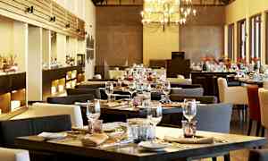 En elegant restaurant med dekkede bord og en lysekrone. (AI-generert tekst)