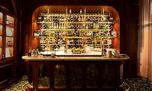 En elegant bar med flasker på hyller bak en marmordisk. (AI-generert tekst)