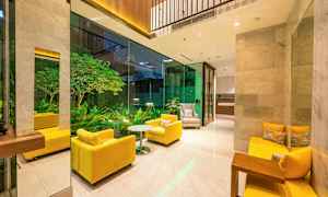 En lounge med gule sofaer og glassvegg som vender mot en grønn hage. (AI-generert tekst)