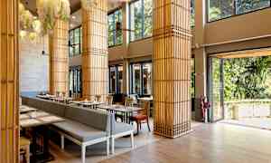 Et lyst restaurantområde med store vinduer og dekorative søyler. (AI-generert tekst)