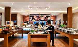 Bufféområdet i en restaurant med matstasjoner og sitteplasser. (AI-generert tekst)