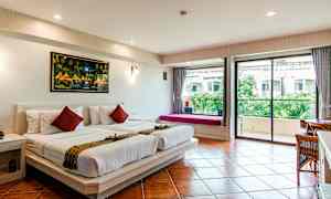 Et hotellrom med to enkeltsenger dekket med hvite laken, et maleri på veggen over, og en glassdør som fører til en balkong med utsikt over grøntområder. (AI-generert tekst)