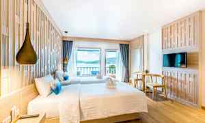 Hotellrom med to senger, utsikt over havet og moderne innredning. (AI-generert tekst)