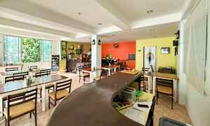 Bilde av et innemiljø med bord, stoler og fargerike vegger. (AI-generert tekst)