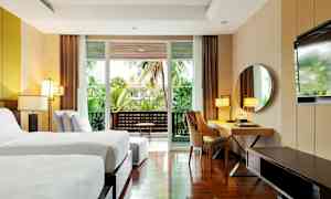 Moderne hotellrom med to enkeltsenger, skrivebord, speil og balkong med grønn utsikt. (AI-generert tekst)