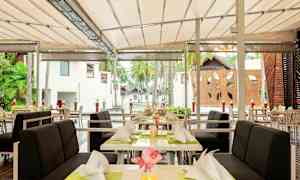 Uteområde med oppdekkede bord og stoler under tak. (AI-generert tekst)