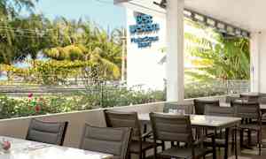 Utendørs servering med utsikt over frodige trær og blomster. (AI-generert tekst)