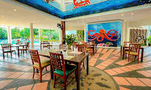 Restaurant med tremøbler, fargerike veggmalerier med havstema, og et basseng i bakgrunnen. (AI-generert tekst)