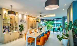 Bilde av en moderne kafé med oransje stoler og grønn dekor. (AI-generert tekst)