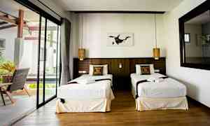 Dobbeltrom med to enkeltsenger, vindu og dekorerte puter. (AI-generert tekst)