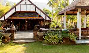 En åpen restaurant med en tradisjonell bygning i grønne omgivelser. (AI-generert tekst)