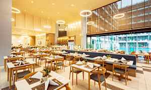 Bilde av en restaurant med oppsatte bord og stoler i et moderne miljø. (AI-generert tekst)