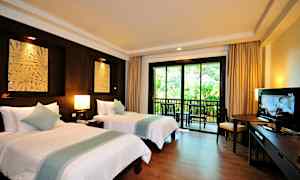 Et hotellrom med to enkeltsenger, en balkong med utsikt over vegetasjon, møbler og en TV. (AI-generert tekst)