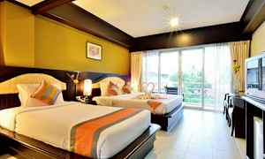 Hotellrom med to senger, lys innredning og balkong med utsikt. (AI-generert tekst)