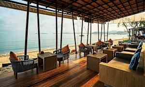 Utendørs servering med sitteplasser ved sjøen. (AI-generert tekst)