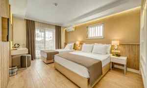 Et hotellrom med to senger, moderne innredning og en balkong. (AI-generert tekst)