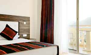 Hotellrom med enkeltseng og balkong med utsikt. (AI-generert tekst)