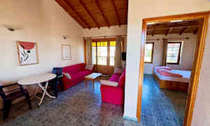 Stue med røde sofaer og tremøbler samt et tilknyttet soverom. (AI-generert tekst)