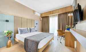 Bilde av et hotellrom med en dobbeltseng, skrivebord, stol og TV. (AI-generert tekst)