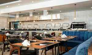 Restaurant med dekkede bord og en buffédisk i bakgrunnen. (AI-generert tekst)