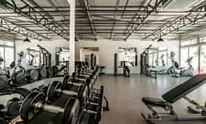 Treningsstudio med treningsmaskiner, manualer og speil. (AI-generert tekst)