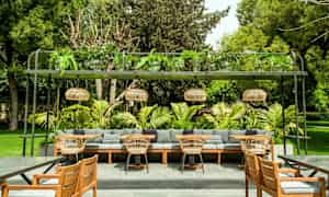 Utendørsområde med sitteplasser, sofaer, stoler og grønne omgivelser. (AI-generert tekst)