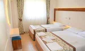 Hotellrom med to enkeltsenger, lys gardiner og et speil. (AI-generert tekst)