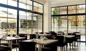 Restaurant med dekkede bord og store vinduer. (AI-generert tekst)