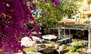 Utendørsområde med parasoller, trær og sitteplasser. (AI-generert tekst)