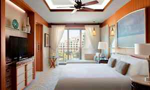 Hotellrom med dobbeltseng, balkong og moderne innredning. (AI-generert tekst)