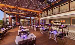 En restaurantterrasse med dekte bord og lysslynger i taket. (AI-generert tekst)