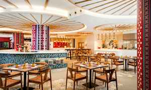 Interiør av en fargerik og stilfull restaurant med trebord og stoler. (AI-generert tekst)